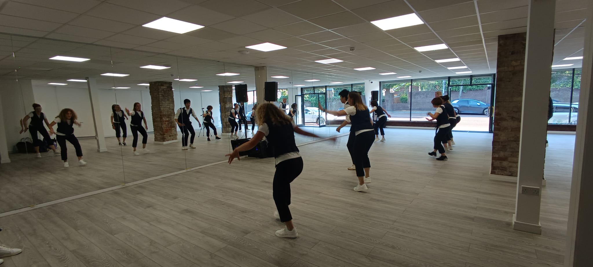 Dancers on the Peters Hill floor, the street visible through the shopfront glass.